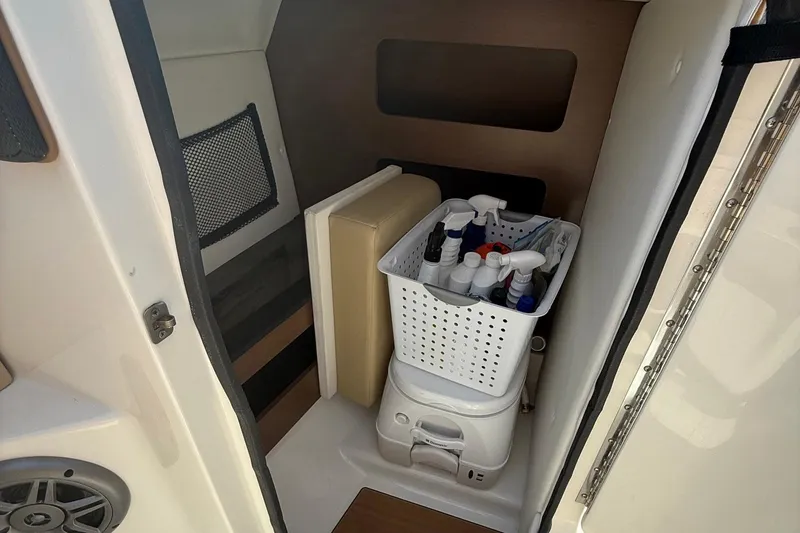 Slide: The Image of Interior of 2014 Sea Ray 240 Sundeck Outboard with storage and cleaning supplies. - 6