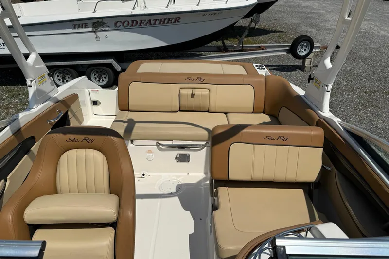 Slide: The Image of 2014 Sea Ray 240 Sundeck Outboard interior with tan leather seating and logo. - 9