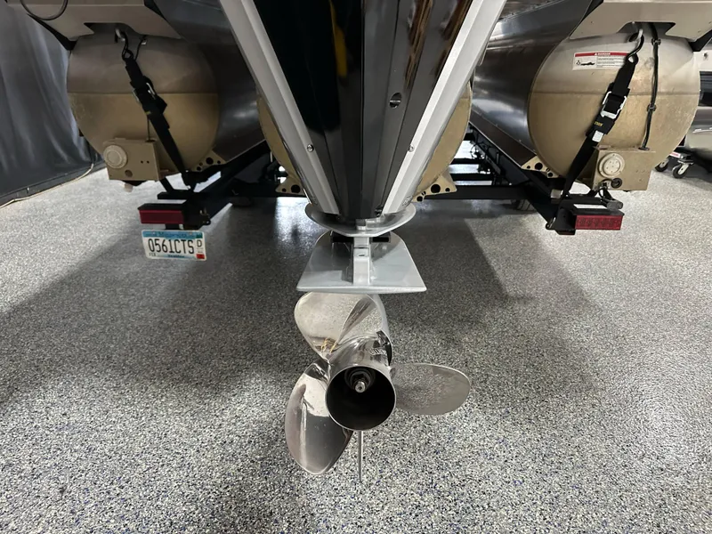 Slide: The Image of 2021 Barletta 23QCSS pontoon boat propeller and pontoons on display in a showroom. - 11
