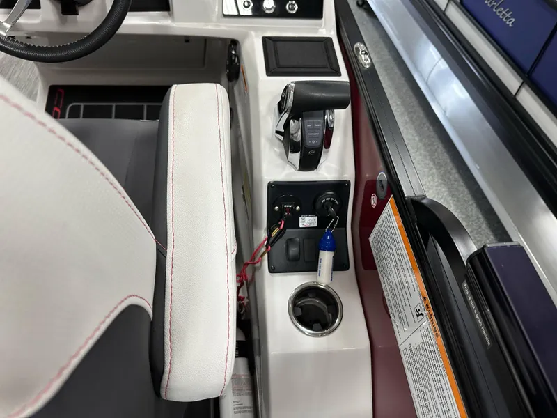 Slide: The Image of 2021 Barletta 23QCSS boat console with controls, cup holder, and warning label. - 24