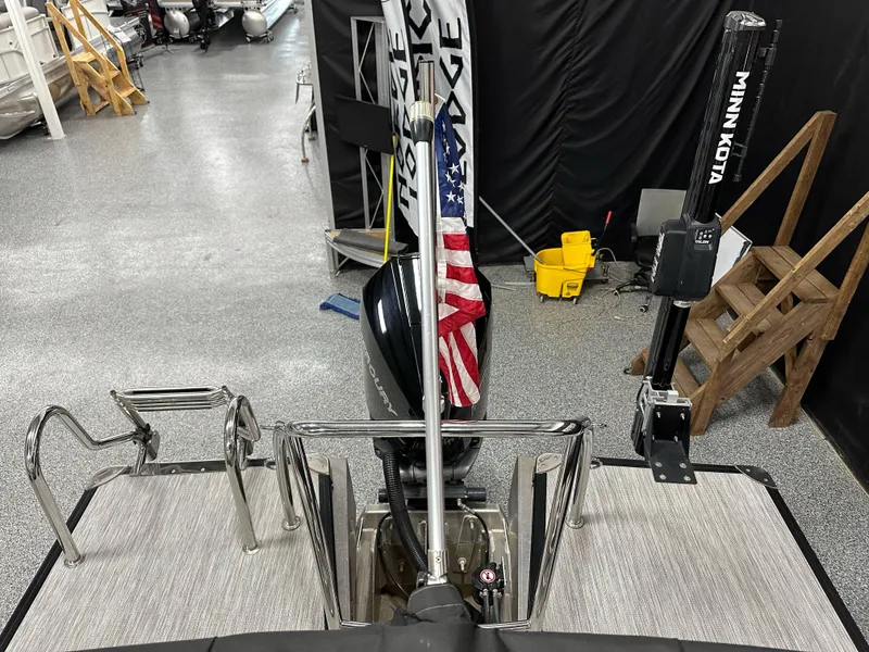 Slide: The Image of 2021 Barletta 23QCSS boat with Minn Kota motor and American flag in showroom. - 26