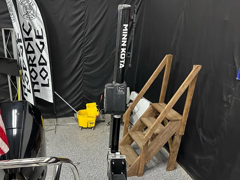 Slide: The Image of Minn Kota motor beside wooden steps, Nordic Lodge banner, and cleaning supplies in a garage. - 28