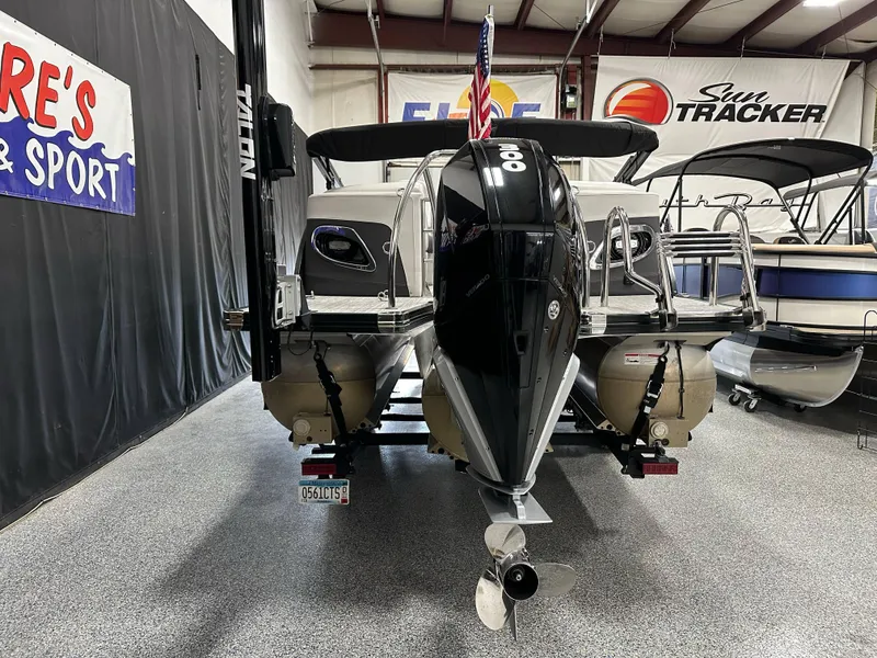 Slide: The Image of 2021 Barletta 23QCSS pontoon boat in showroom, rear view with motor and ladder. - 3