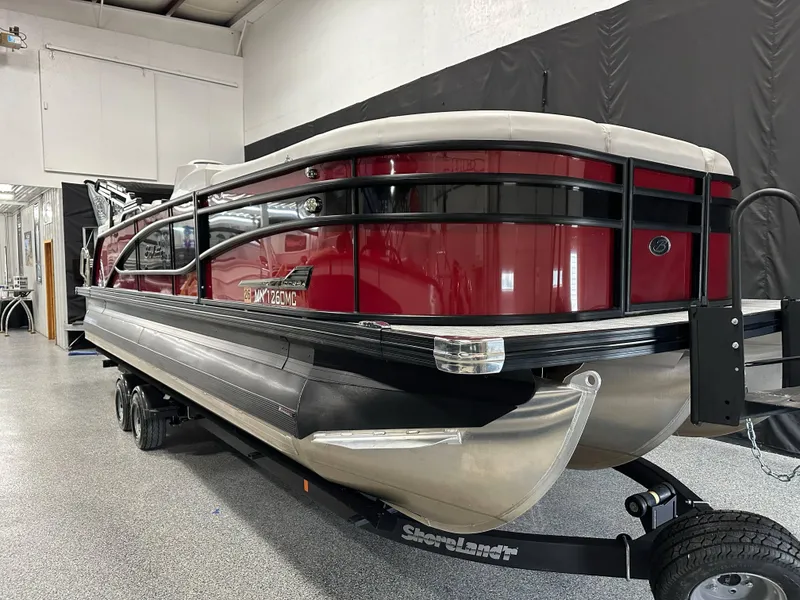 Slide: The Image of 2021 Barletta 23QCSS pontoon boat in showroom, red and black design, on trailer. - 6