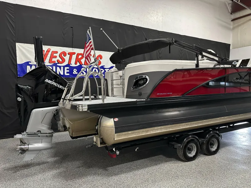 Slide: The Image of 2021 Barletta 23QCSS pontoon boat with Mercury engine on display indoors. - 7