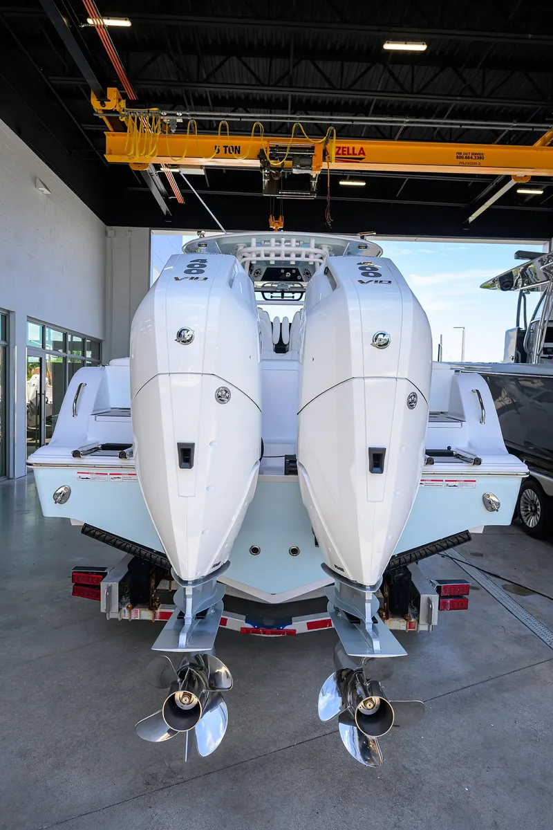 Slide: The Image of 2026 Sportsman Heritage 321 Center Console with dual outboard engines in a showroom. - 21