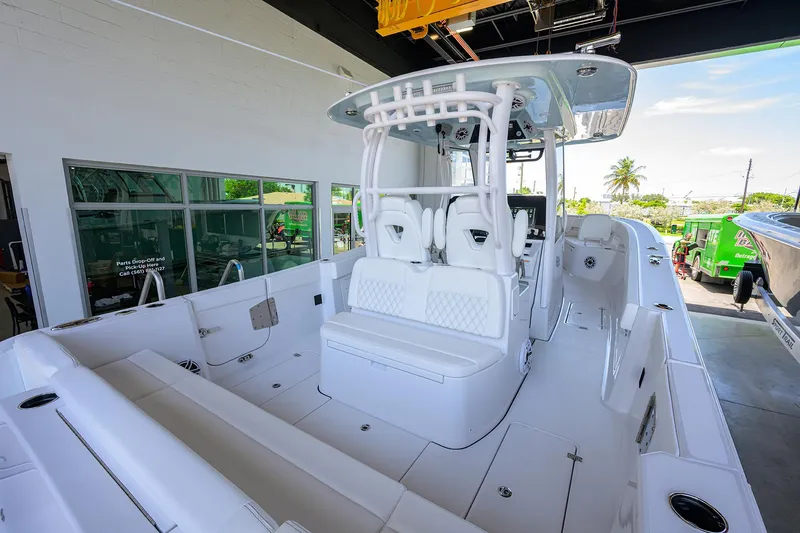 Slide: The Image of 2026 Sportsman Heritage 321 Center Console boat in showroom, featuring sleek white design. - 28