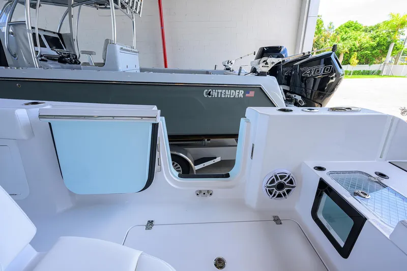 Slide: The Image of 2026 Sportsman Heritage 321 Center Console boat interior with open door and visible Contender boat. - 35