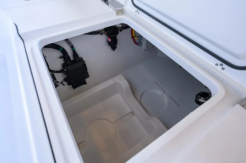 Slide: The Image of 2026 Sportsman Heritage 321 Center Console storage compartment with wiring and components. - 36