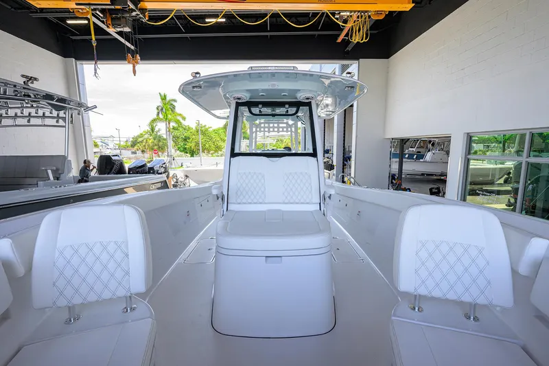 Slide: The Image of 2026 Sportsman Heritage 321 Center Console boat interior with white seating in a showroom. - 5