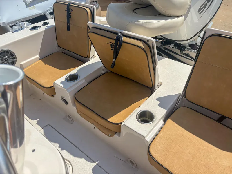 Slide: The Image of 2024 Carolina Skiff 22 Ultra Elite boat seating with tan cushions and cup holders. - 15