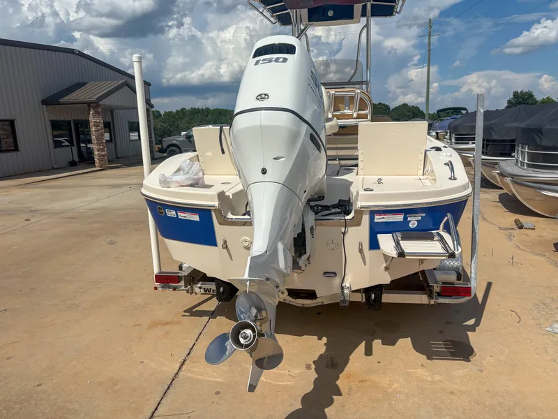 Slide: The Image of 2024 Carolina Skiff 22 Ultra Elite boat with outboard motor, parked outdoors. - 6