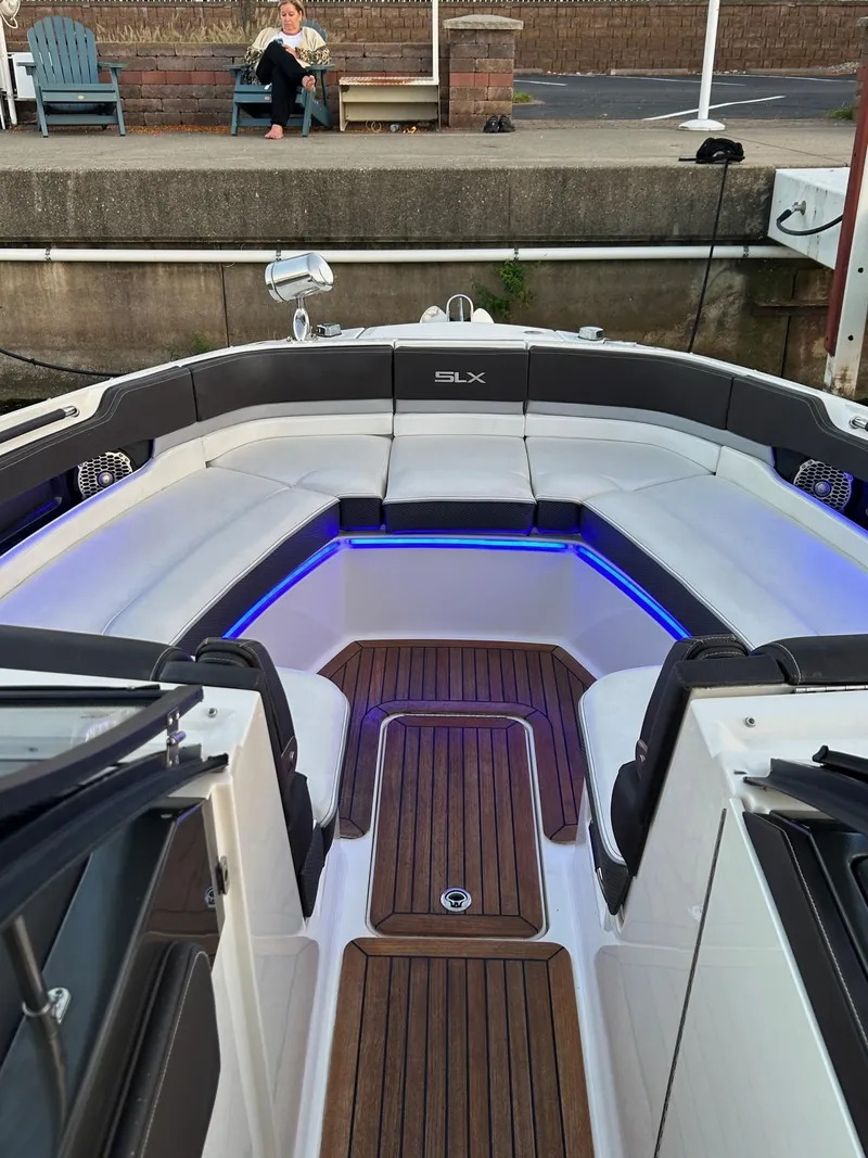 Slide: The Image of 2016 Sea Ray 310 SLX boat interior with wood flooring and blue LED lighting. - 10