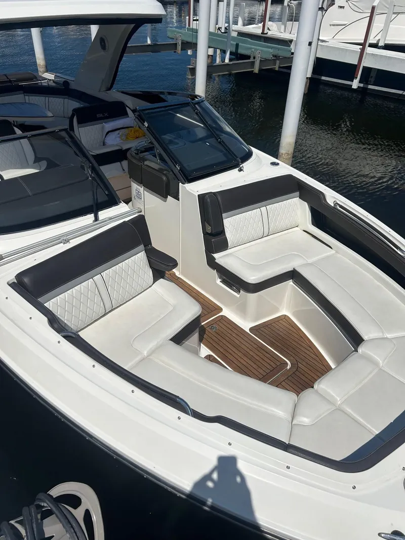 Slide: The Image of 2016 Sea Ray 310 SLX boat with luxurious seating and sleek design at a marina. - 11
