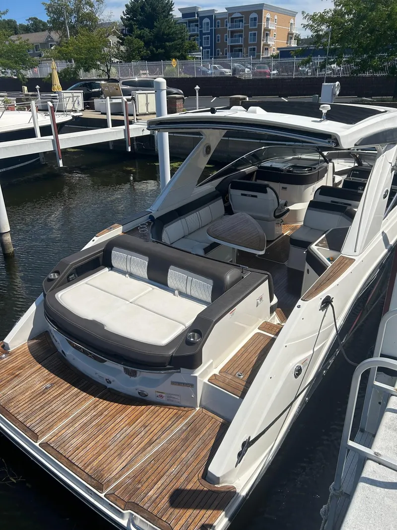 Slide: The Image of 2016 Sea Ray 310 SLX boat docked, featuring spacious seating and sleek design. - 2
