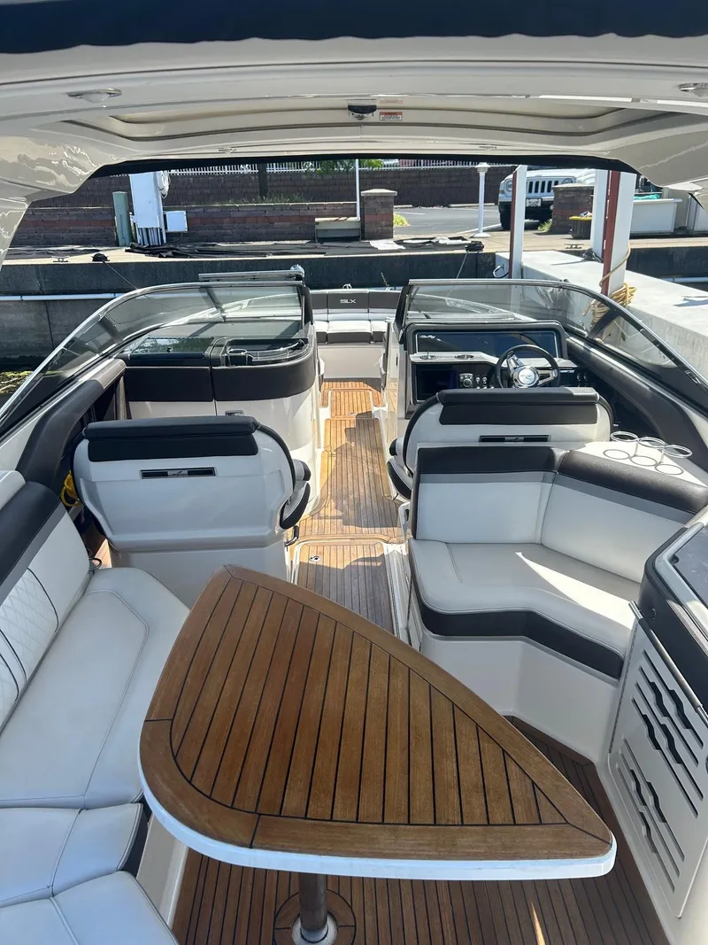 Slide: The Image of 2016 Sea Ray 310 SLX boat interior with luxurious seating and wooden table. - 6