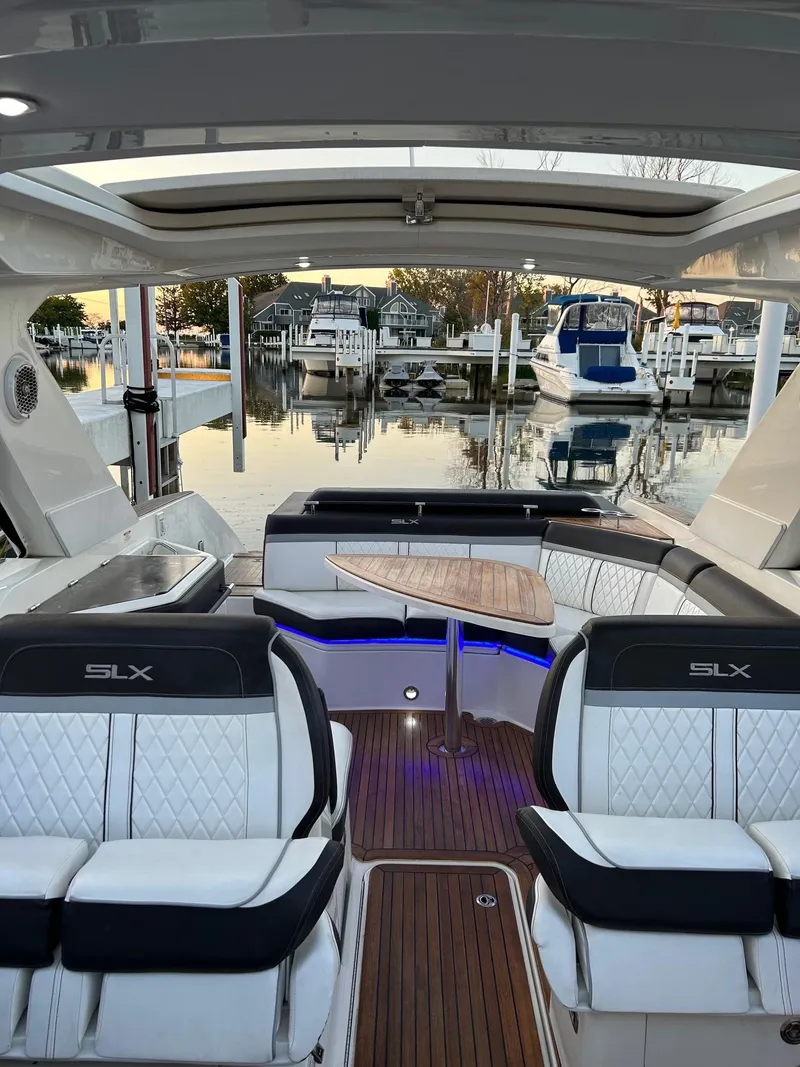 Slide: The Image of Luxurious 2016 Sea Ray 310 SLX boat interior with elegant seating and wooden table. - 9