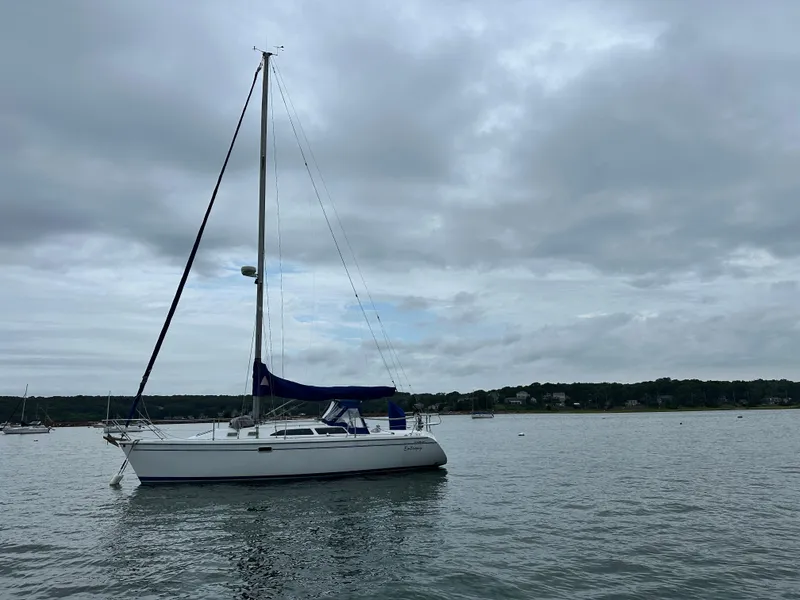 Slide: The Image of Sailboat Catalina 320 from 1999 on calm waters under cloudy skies. - 1