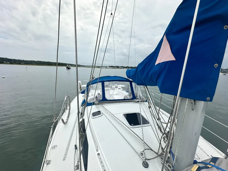 Slide: The Image of Sailboat Catalina 320, 1999 model, on calm water under cloudy sky. - 10