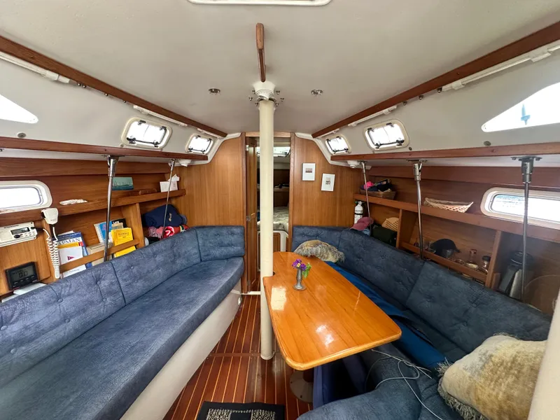 Slide: The Image of Interior of 1999 Catalina 320 sailboat with cozy seating and wooden table. - 18