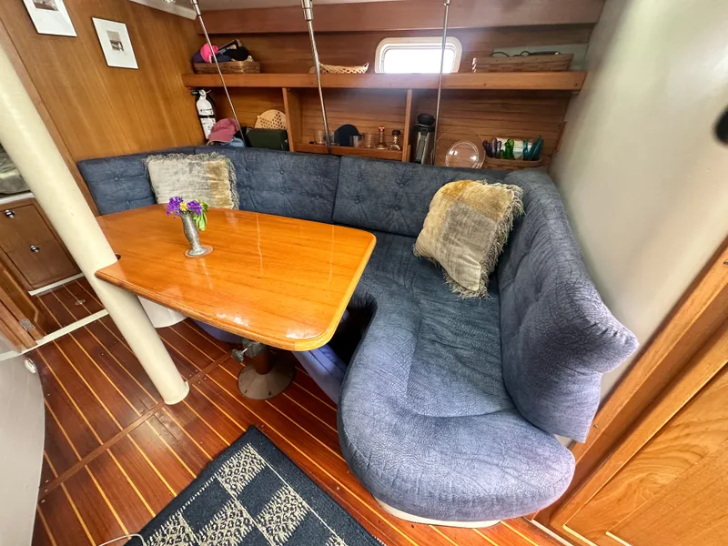 Slide: The Image of Cozy interior of 1999 Catalina 320 sailboat with blue seating and wooden table. - 19