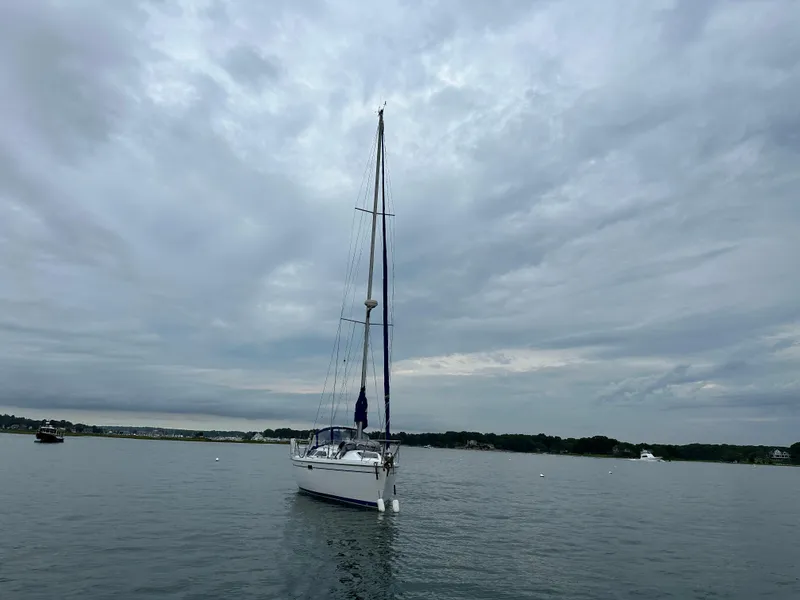 Slide: The Image of Sailboat Catalina 320 (1999) on calm water under cloudy sky. - 2