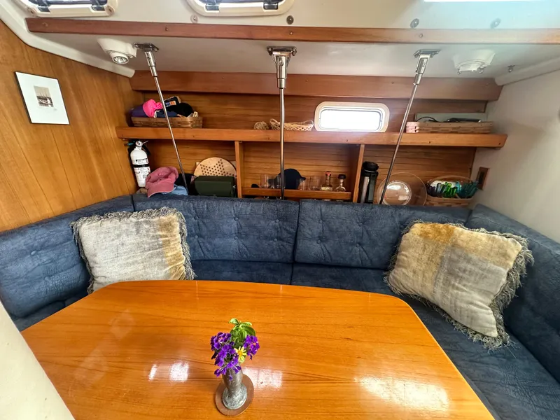 Slide: The Image of Cozy interior of 1999 Catalina 320 sailboat with blue seating and wooden table. - 20