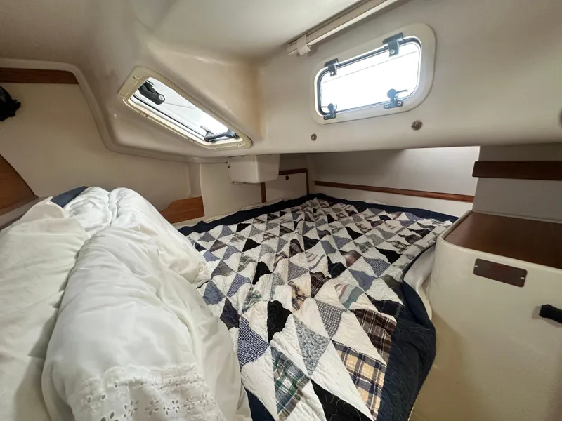 Slide: The Image of Cozy cabin interior of a 1999 Catalina 320 sailboat with quilted bedding. - 25