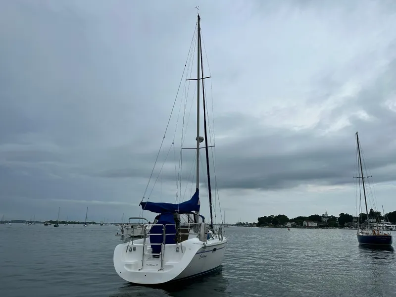 Slide: The Image of Sailboat Catalina 320 (1999) anchored on a cloudy day in a calm harbor. - 3