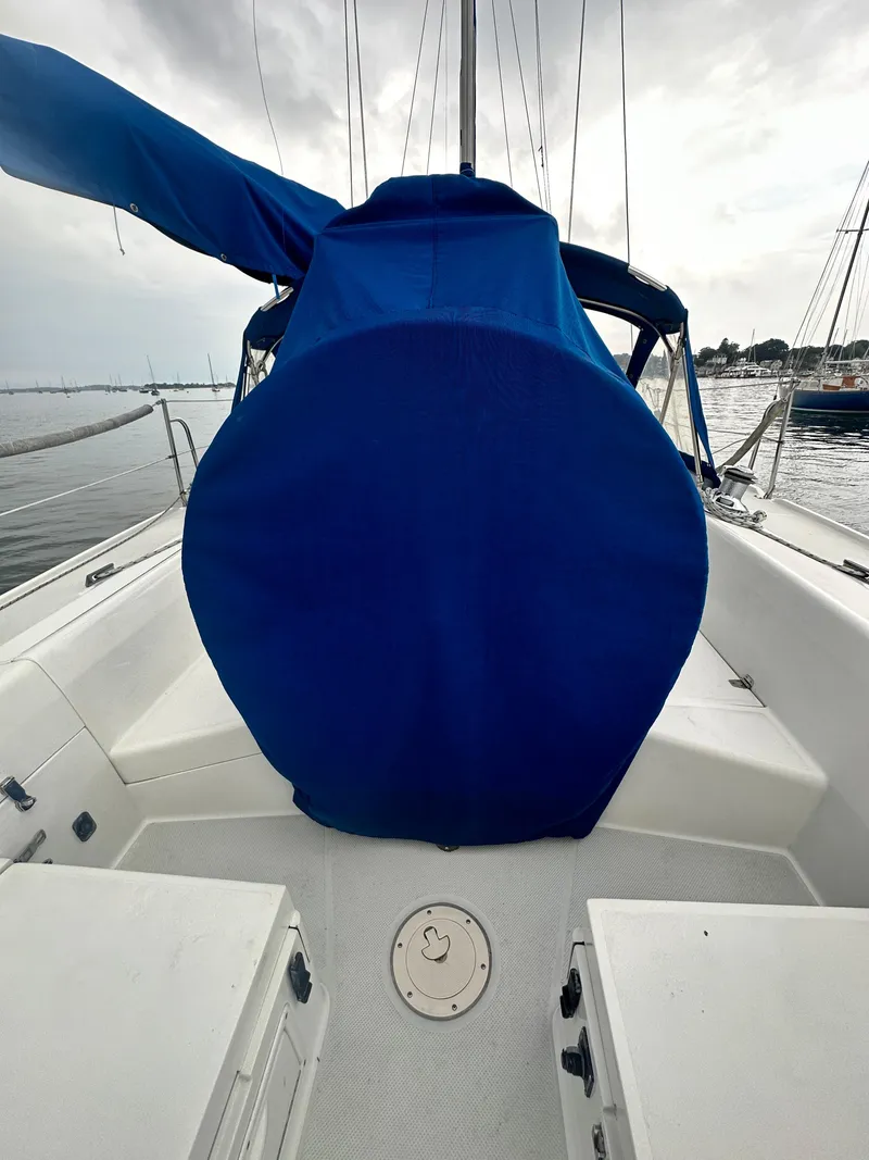 Slide: The Image of 1999 Catalina 320 sailboat deck with blue sail cover, docked at marina. - 4