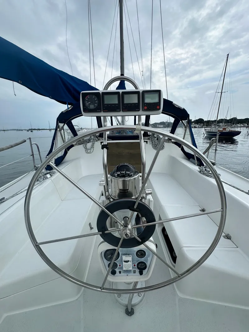Slide: The Image of Cockpit view of a 1999 Catalina 320 sailboat with steering wheel and instruments. - 5