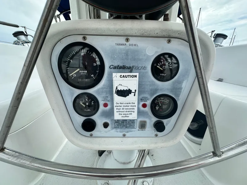 Slide: The Image of Control panel of a 1999 Catalina 320 yacht with gauges and caution label. - 8