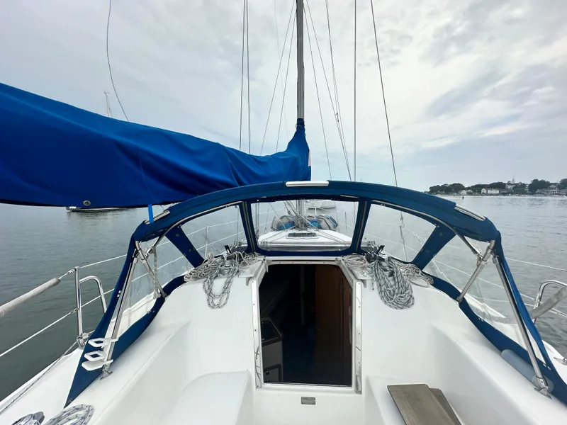 Slide: The Image of Sailboat cockpit view, 1999 Catalina 320, with blue canopy and calm waters. - 9