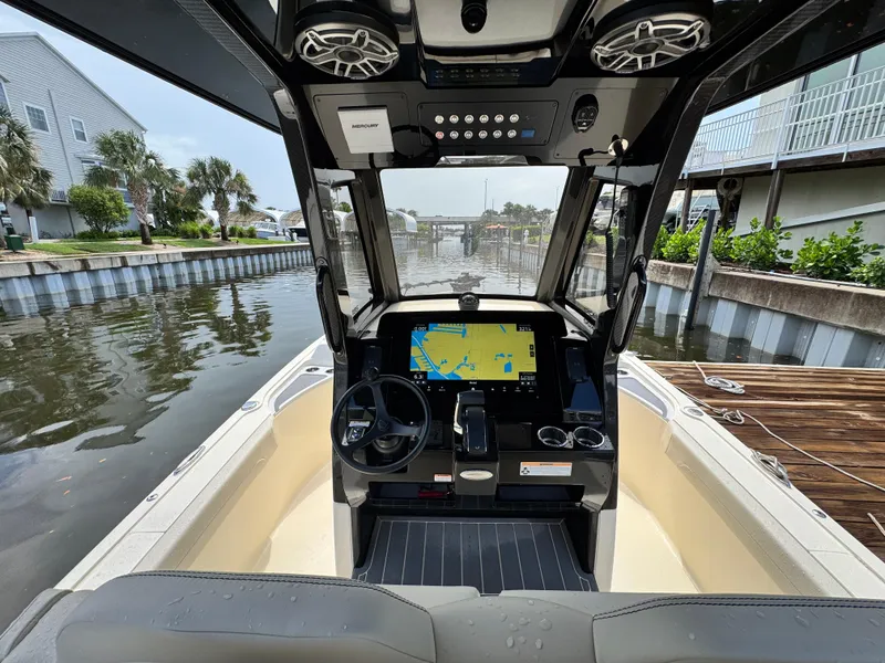 Slide: The Image of 2026 Scout 281 XSS boat interior with advanced navigation system, docked in a canal. - 13