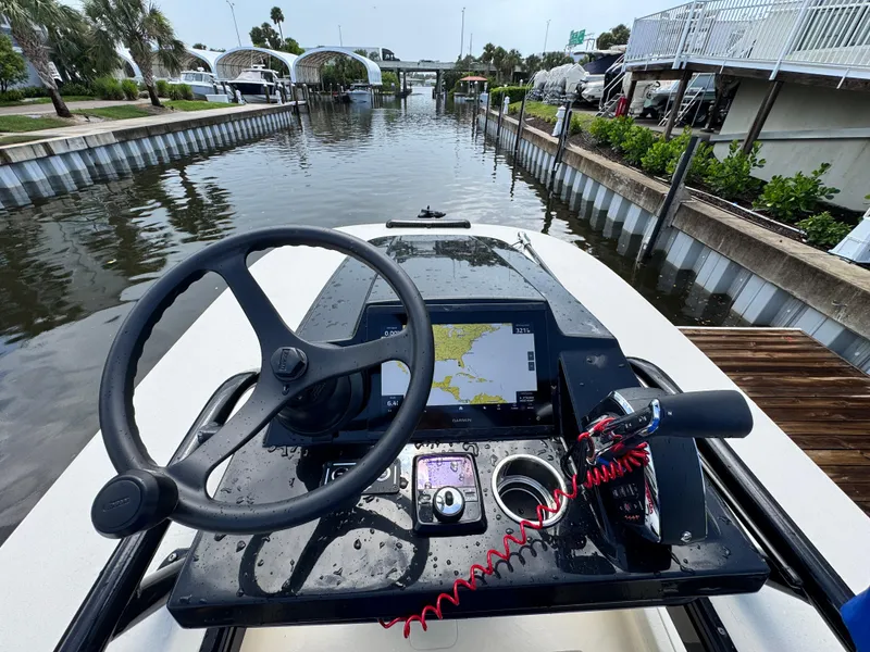 Slide: The Image of Steering console of 2026 Scout 281 XSS boat with navigation display, docked in a canal. - 17
