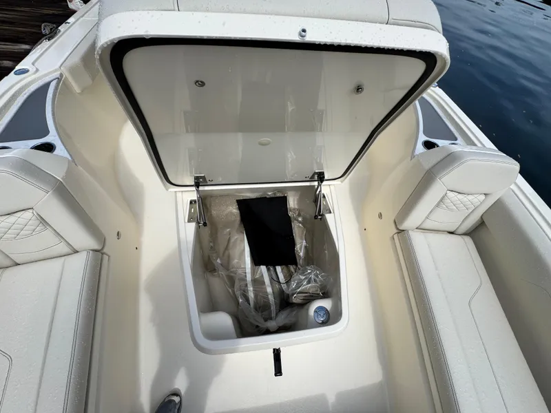 Slide: The Image of 2026 Scout 281 XSS boat storage compartment open, showcasing interior space and seating. - 22