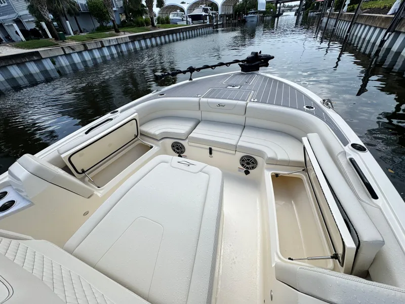 Slide: The Image of 2026 Scout 281 XSS boat interior with seating and storage, docked by a canal. - 25