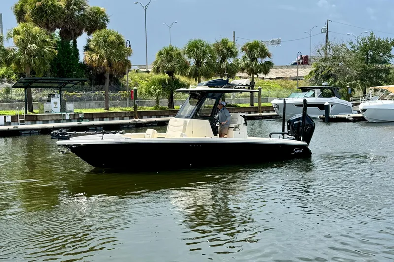 Slide: The Image of 2026 Scout 281 XSS boat cruising on a calm waterway near a marina. - 4