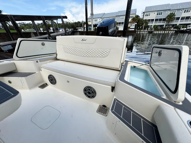 Slide: The Image of 2026 Scout 281 XSS boat interior with seating, storage, and speakers by the water. - 9