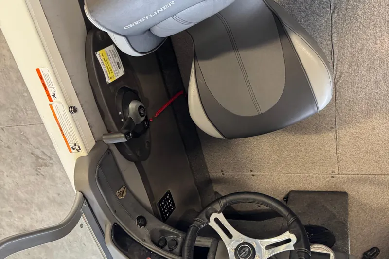 Slide: The Image of Interior of a 2017 Crestliner 1850 Sportfish Outboard boat, featuring steering wheel and seat. - 8