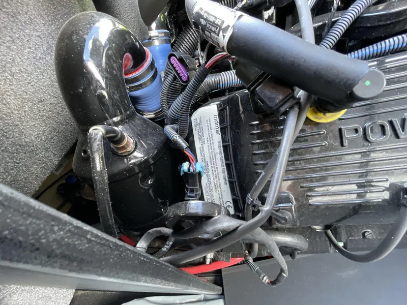 Slide: The Image of Engine components of a 2015 Moomba Mobius LSV boat, featuring wiring and hoses. - 15