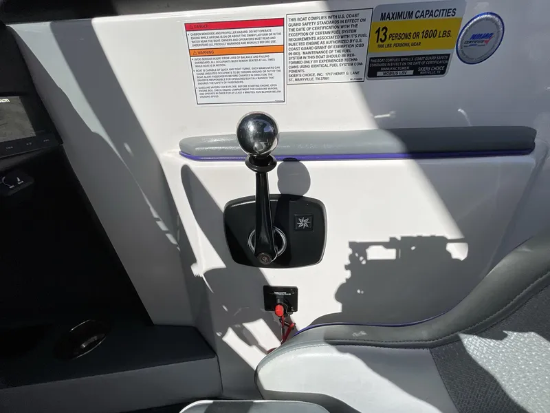 Slide: The Image of 2015 Moomba Mobius LSV boat control panel with gear shift and capacity warning labels. - 26