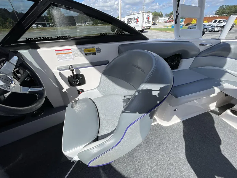 Slide: The Image of Interior of a 2015 Moomba Mobius LSV boat, featuring gray seating and steering wheel. - 28