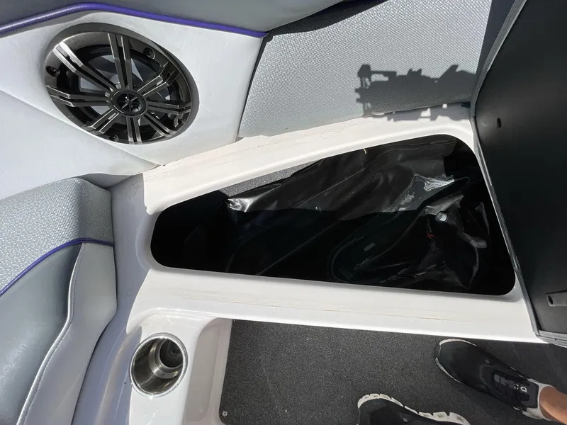 Slide: The Image of 2015 Moomba Mobius LSV boat interior with speaker, storage compartment, and cup holder. - 30