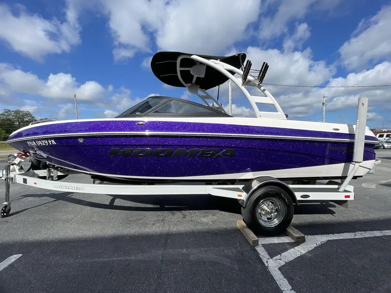 Slide: The Image of 2015 Moomba Mobius LSV boat with purple hull on a trailer under a blue sky. - 4