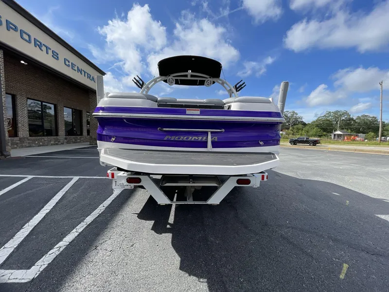 Slide: The Image of 2015 Moomba Mobius LSV boat in parking lot, rear view, under blue sky. - 6