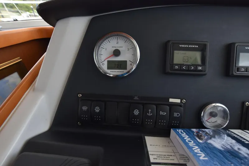 Slide: The Image of Control panel of a 2019 Beneteau Swift Trawler 44 with gauges and Navionics book. - 11