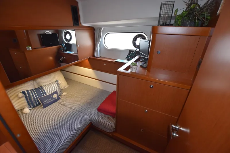 Slide: The Image of Cozy cabin interior of 2019 Beneteau Swift Trawler 44 with wooden furnishings and porthole window. - 20