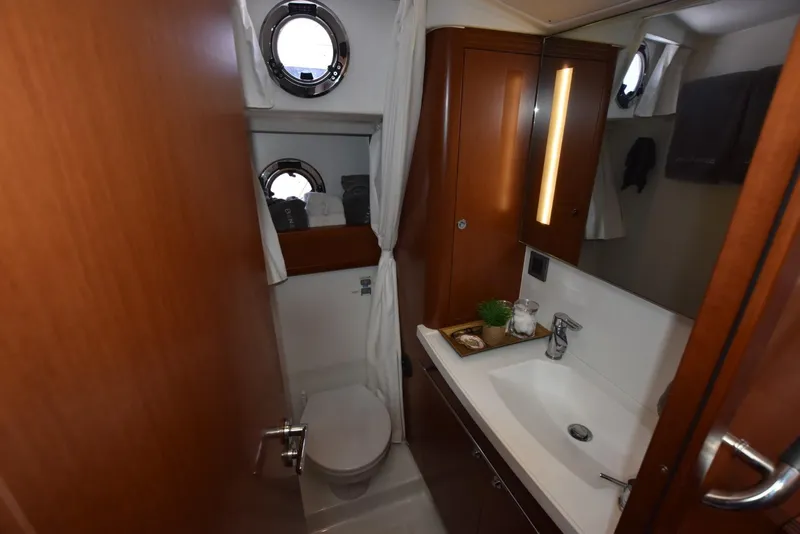 Slide: The Image of Bathroom interior of 2019 Beneteau Swift Trawler 44 with modern fixtures and porthole windows. - 22