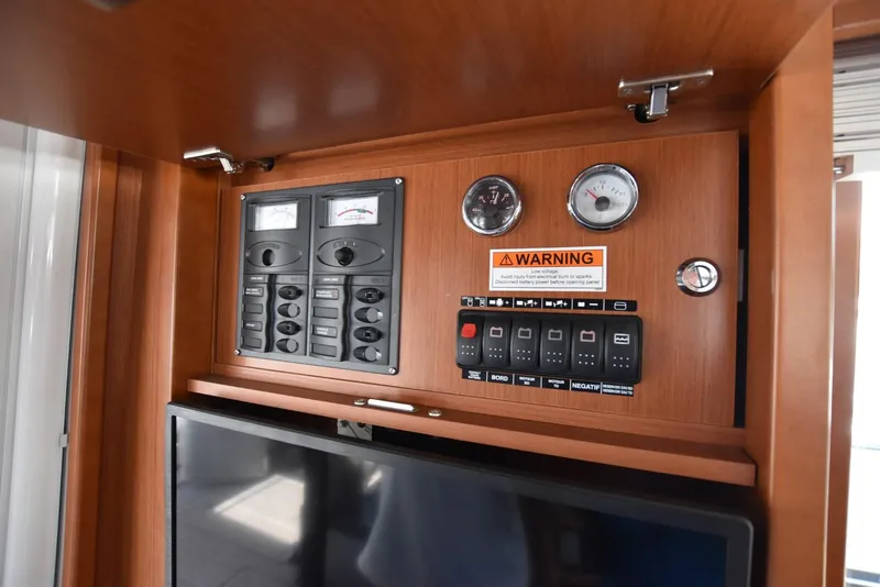 Slide: The Image of Control panel on 2019 Beneteau Swift Trawler 44, featuring gauges and warning label. - 24